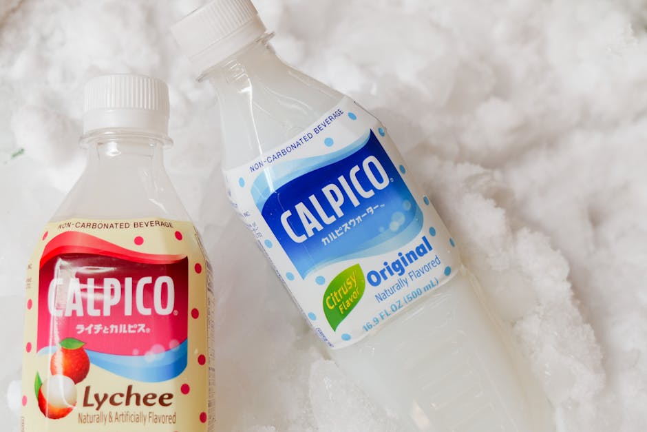 Close-up of two Calpico bottles resting on crushed ice, featuring lychee and original flavors.
