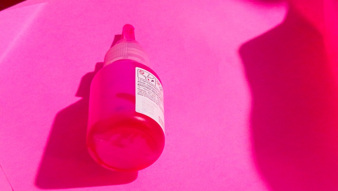 A pink bottle is shown in a pink light.