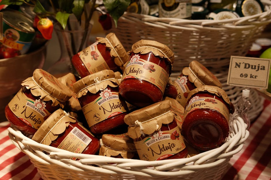 Assortment of Nduja jars in a white basket at a market setting.