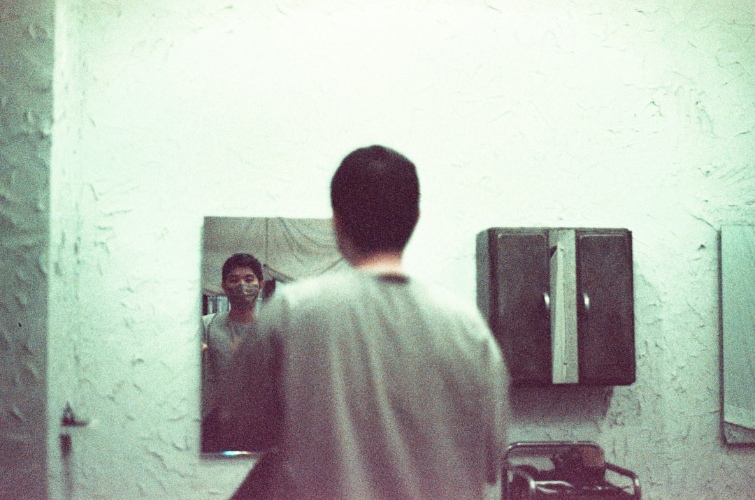 a man standing in front of a mirror in a bathroom