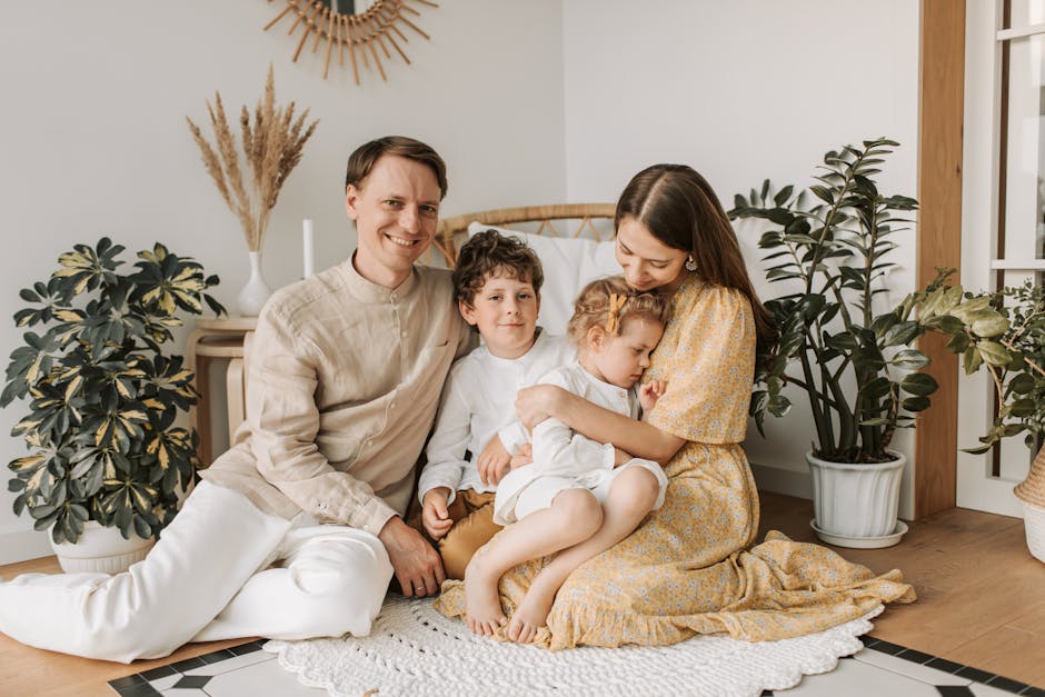 Happy family of four enjoying quality time together in a cozy, plant-filled room.