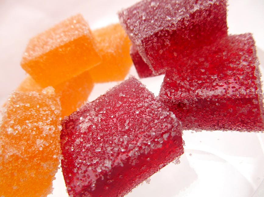 Bright and vibrant sugar-coated red and orange jelly candies in a close-up macro shot.