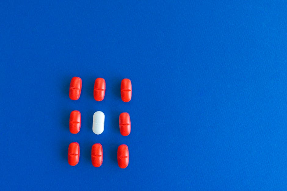 Close-up of red and white tablets arranged on a vibrant blue background.