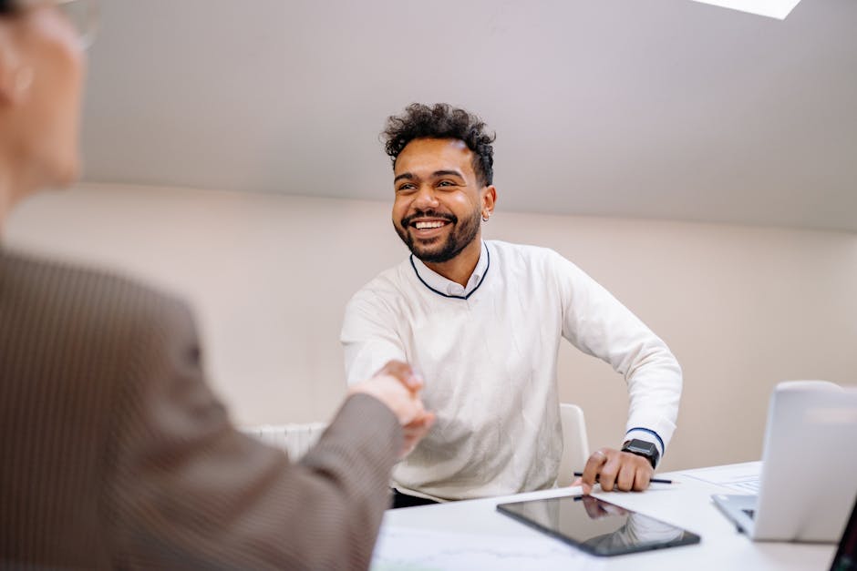 Smiling businessman shaking hands in a modern office. Professional teamwork and agreement concept.