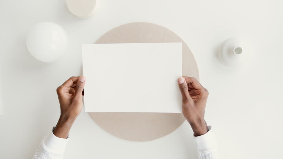 Minimalist mockup featuring hands holding blank paper, perfect for design presentations.