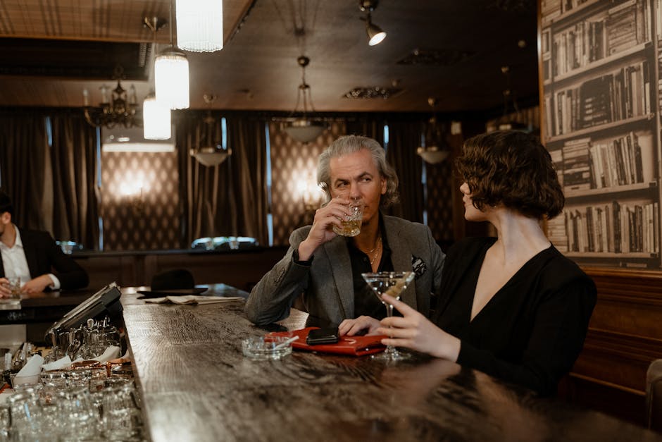 An elegant couple enjoying drinks in an intimate and stylish bar setting.